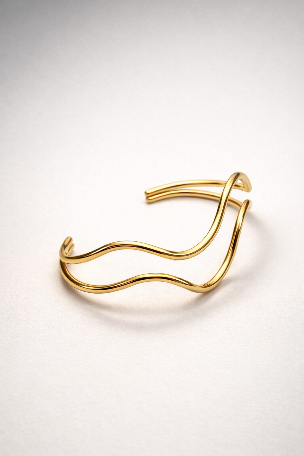 Moderner, goldener Armreif aus Edelstahl in geschwungenem, minimalistischen Design