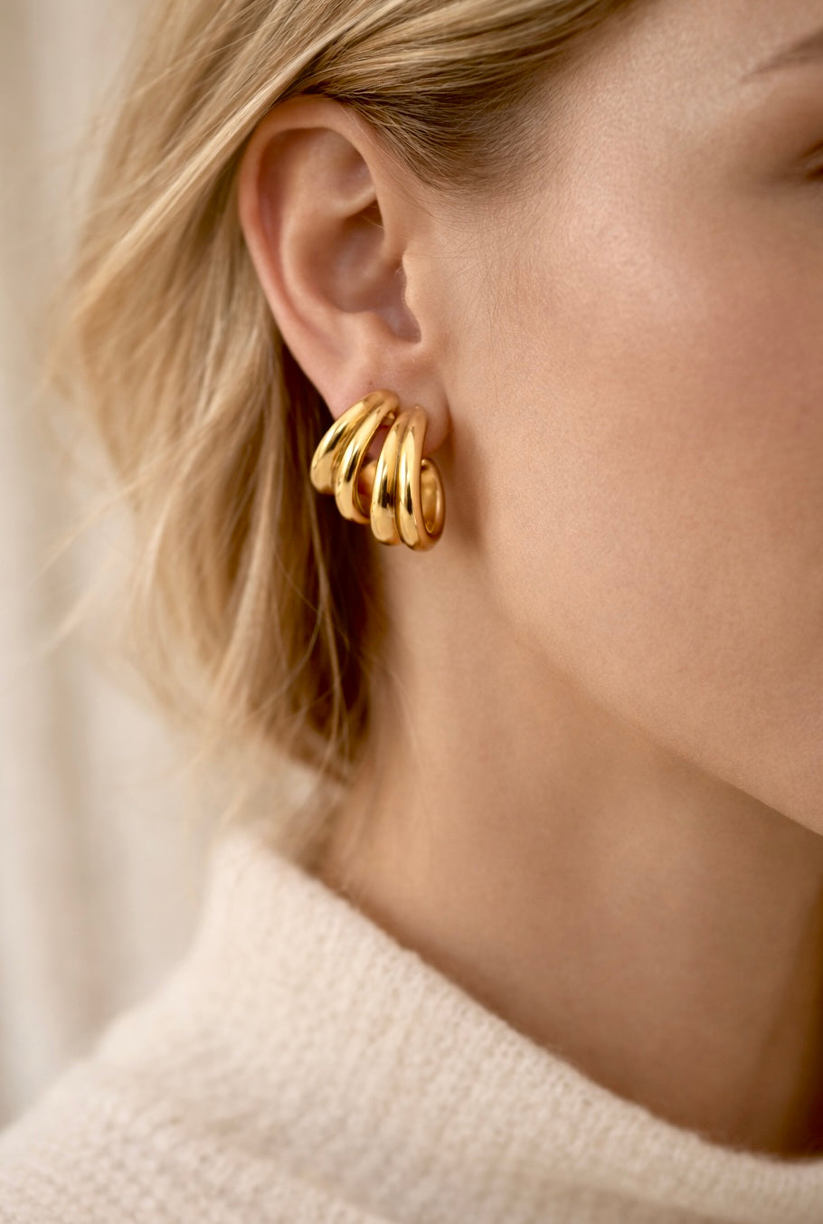 Getragene goldene Creolen mit mehrreihigem Design – moderner Statement-Look von Hesperelle