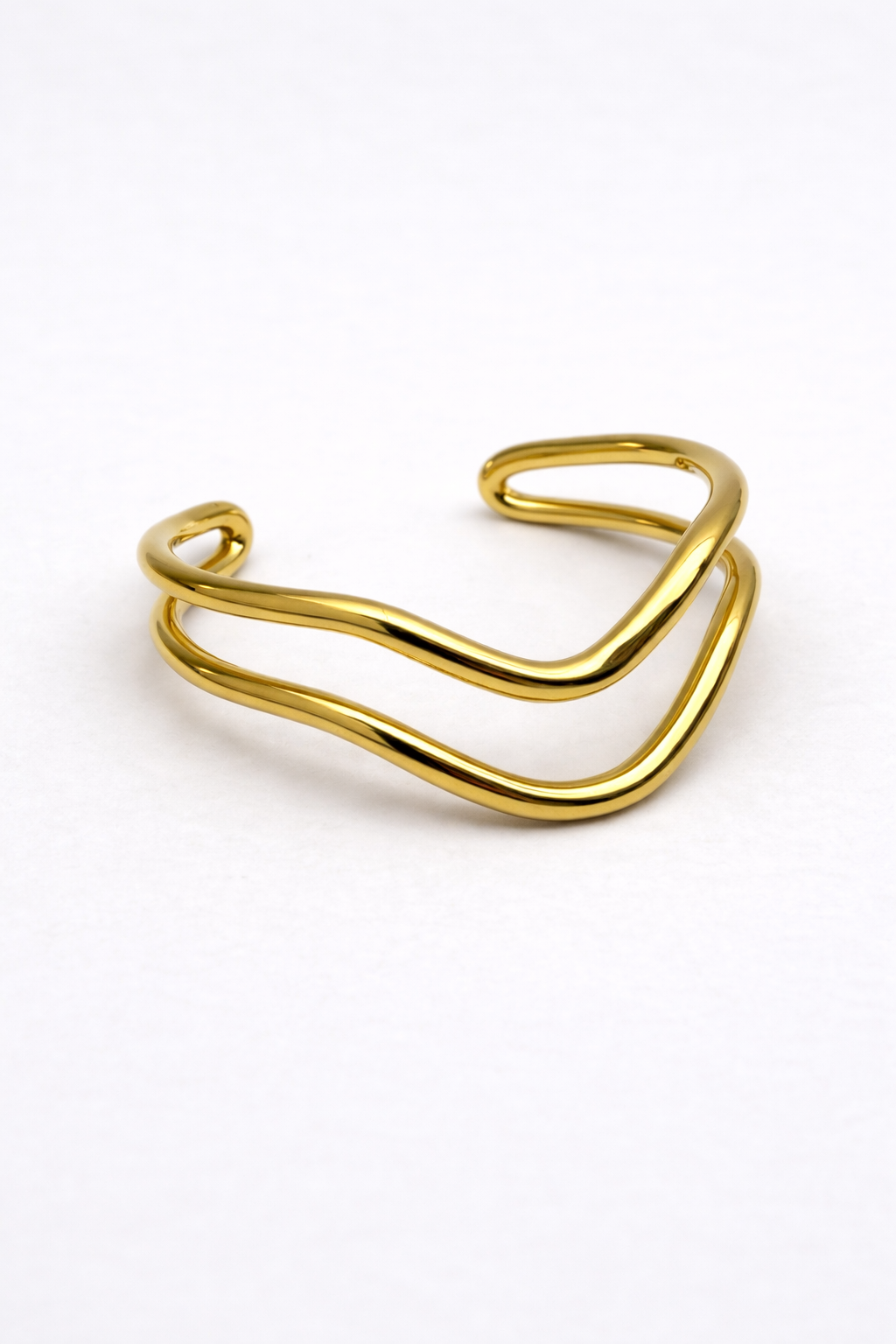 Moderner, goldener Armreif aus Edelstahl in geschwungenem Design – Draufsicht