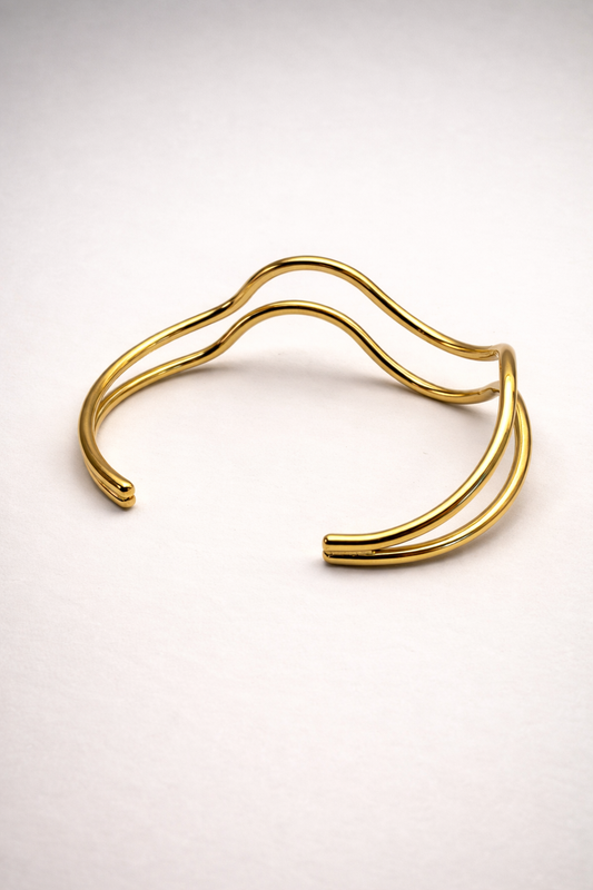 Goldener, offener Armreif aus wasserfestem Edelstahl mit organischer Wellenform von Hesperelle
